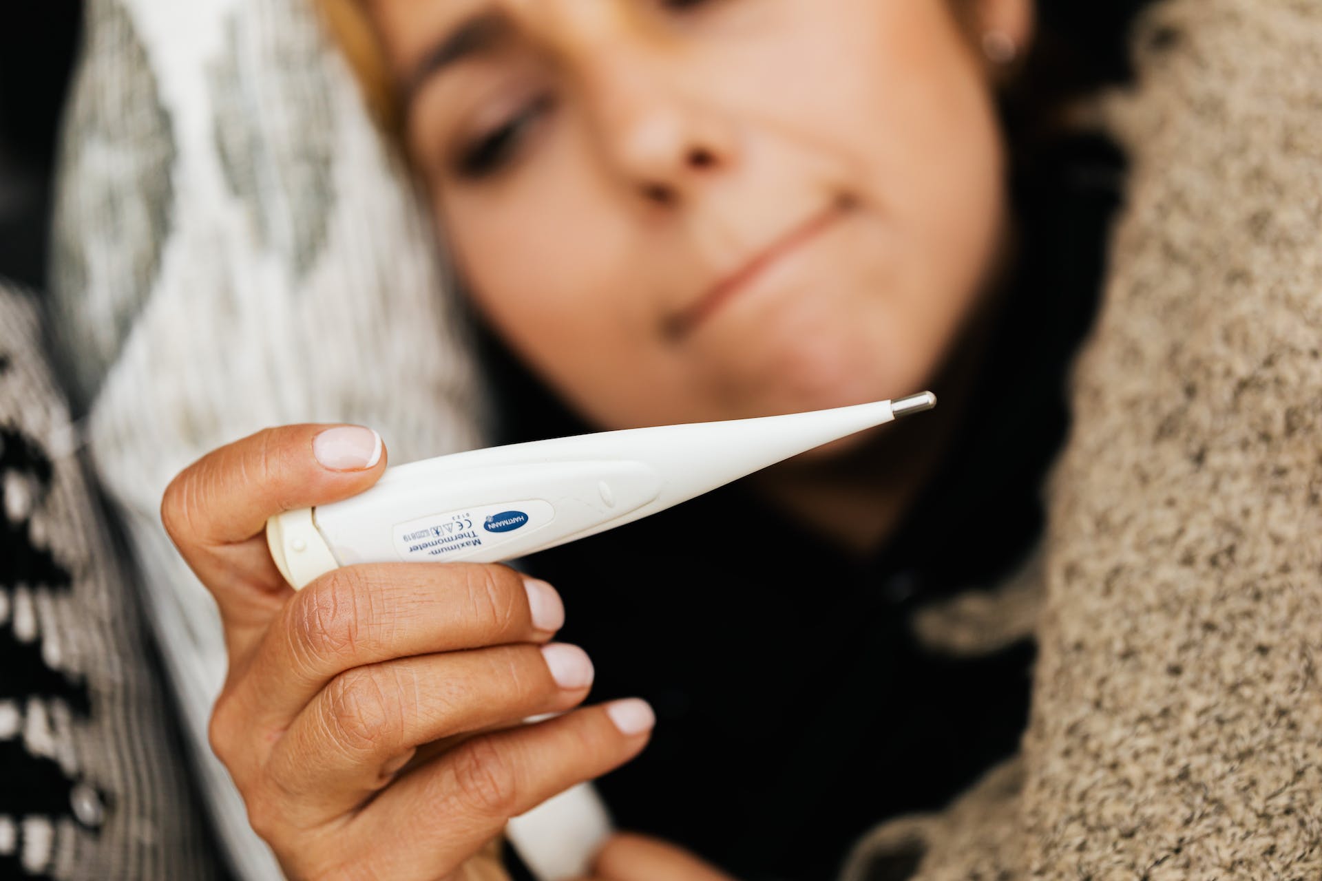 Woman looking at a digital thermometer